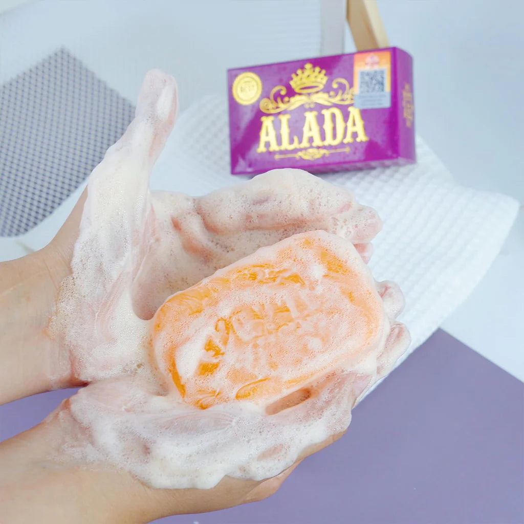 Foamy soap bar held in a hand with 'ALADA' soap box in the background