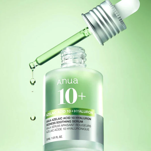 Anua 10+ serum bottle with dropper on a green background