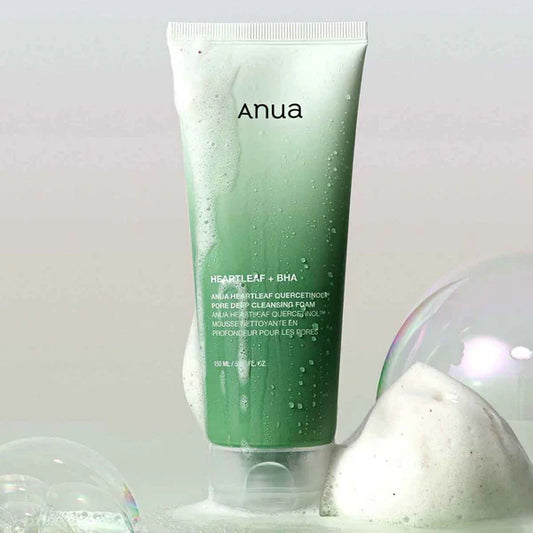 Green tube of Anua skincare product with bubbles on a light gray background