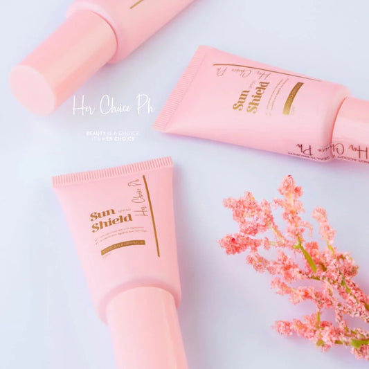 Pink sunscreen tubes with floral design on a light background