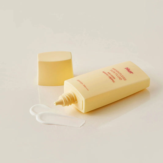 Yellow bottle with pump dispenser on a light beige background