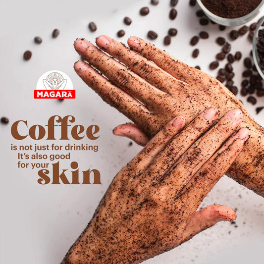Hands with coffee scrub and scattered coffee beans on a light background, featuring the Magara brand.