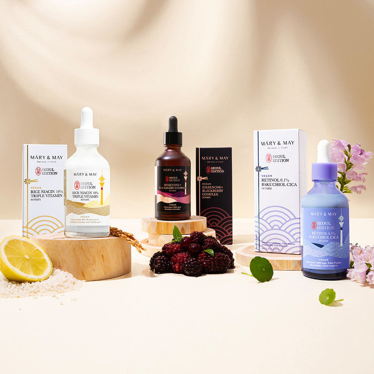 Mary & May skincare products on a neutral background with fruits and flowers.