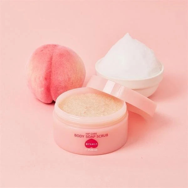 Pink body scrub container with a peach and white scrubber on a pink background