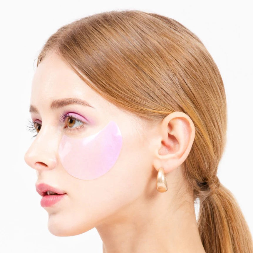 Woman with pink eye patches on a white background