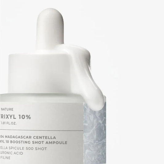 Skincare bottle with dropper labeled 'NATURE DRIXYL 10%' on a white background