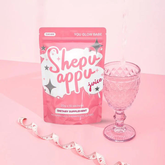 A pack of Shepu Appu slimming juice with a glass and a measuring tape on a pink background.
