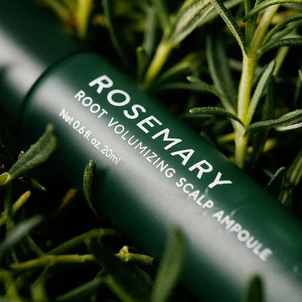 Rosemary root volumizing scalp ampoule bottle with green leaves in the background