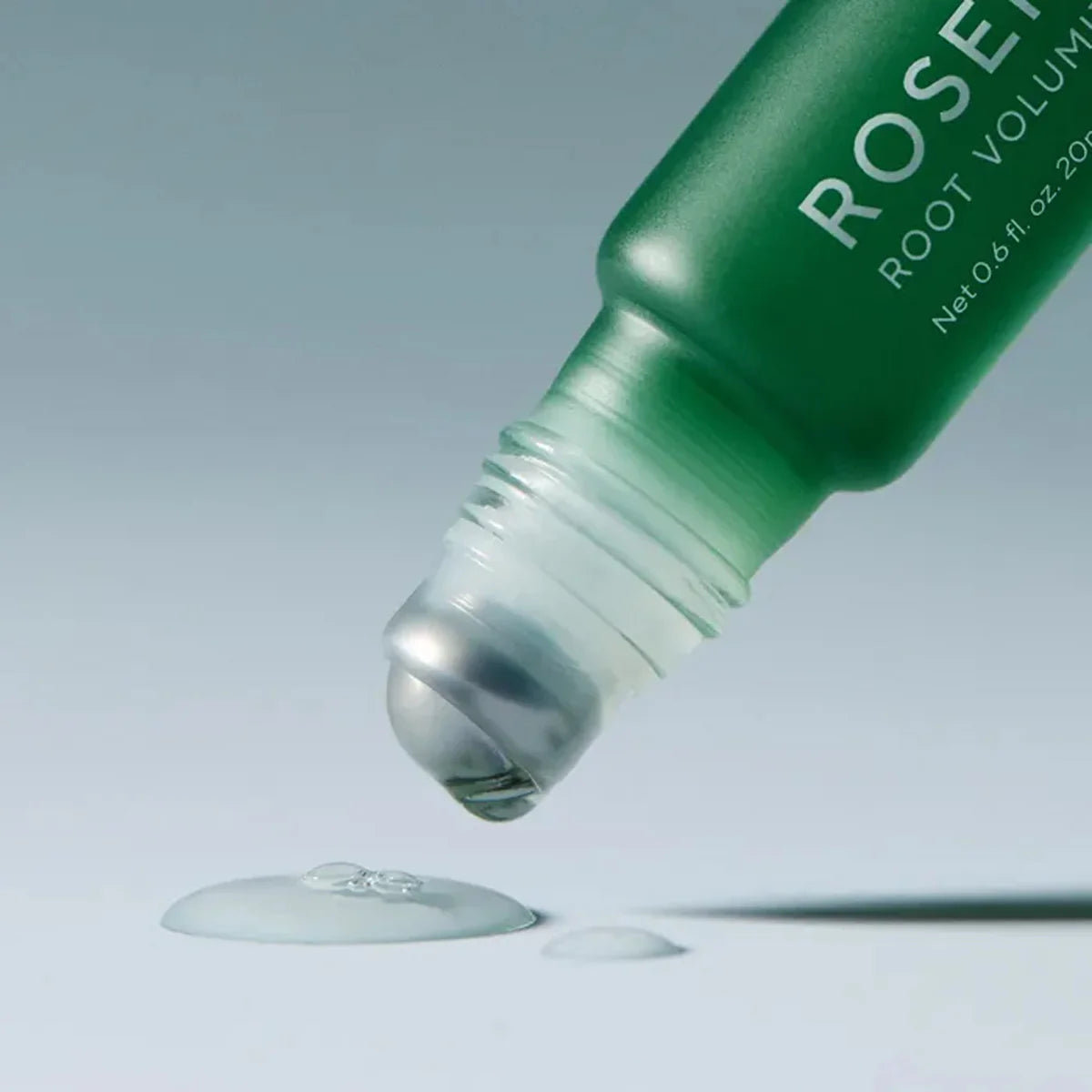 Green bottle of Rosette Root Volumizer with dropper on a light gray background