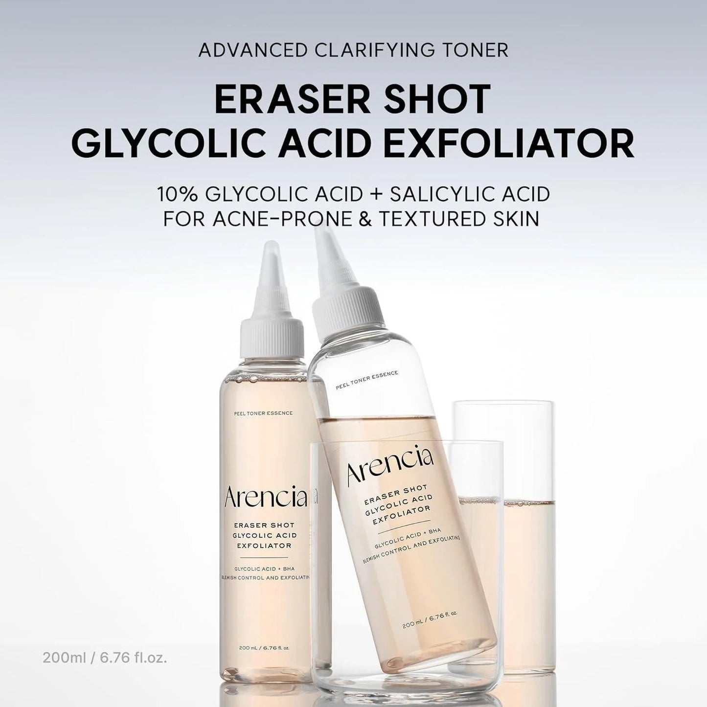 Two clear bottles of Arencia Eraser Shot Glycolic Acid Exfoliator with white dropper-style caps, shown with a glass on a light gray background with product text above.