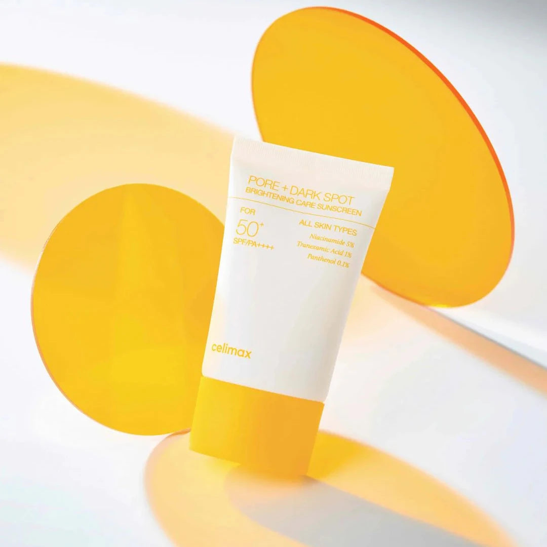 Tube of sunscreen with yellow and orange abstract shapes on a light gray background