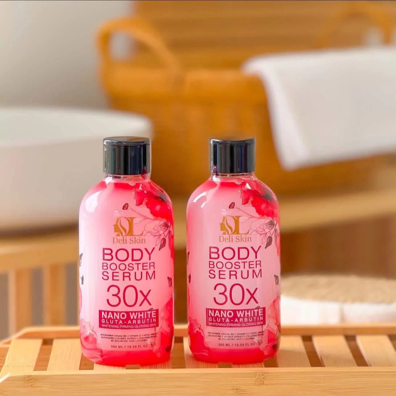 Two bottles of Deli Skin Body Booster Serum 30x on a wooden surface with a blurred background.