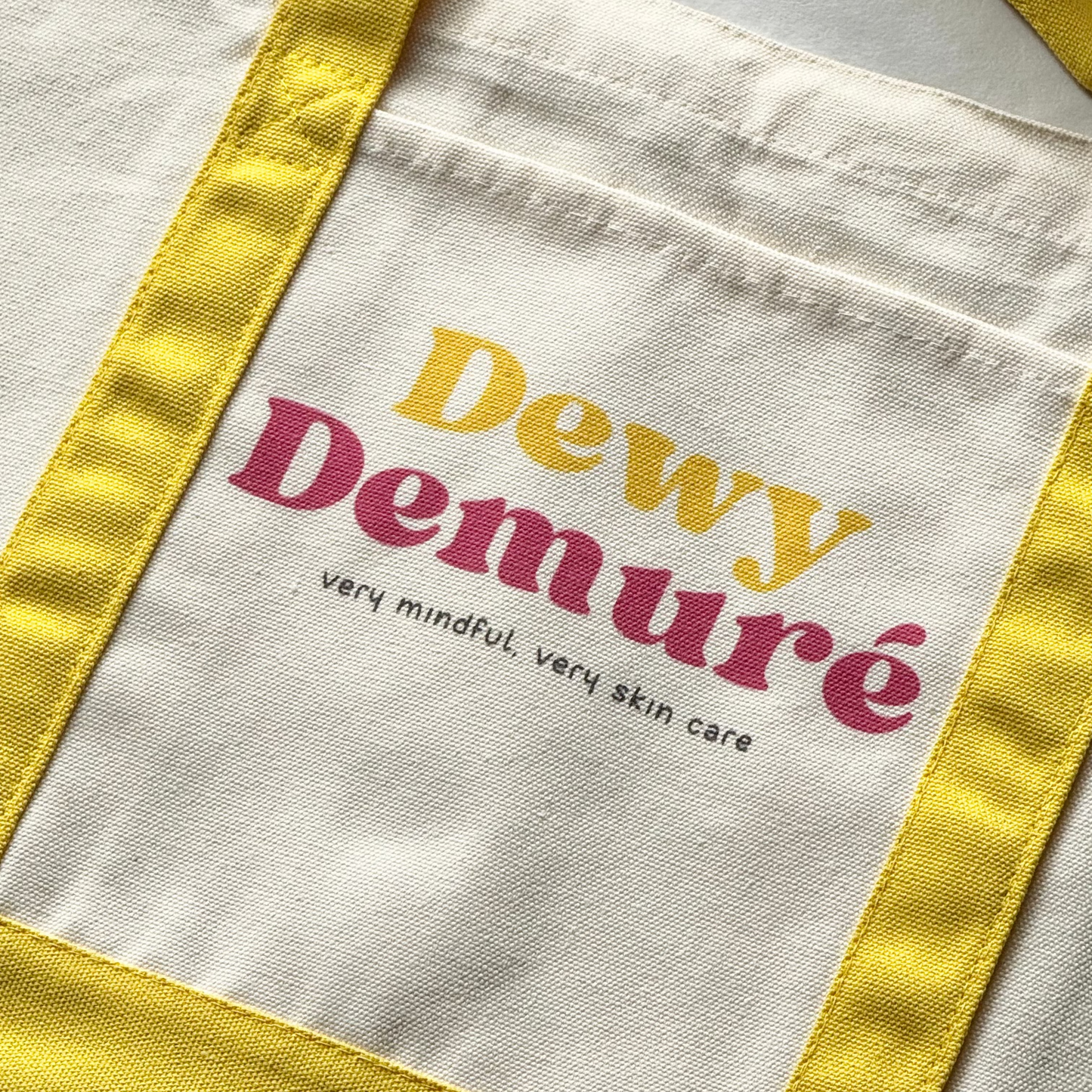 Tote Bag with 'Dewy Demure' text on a light background
