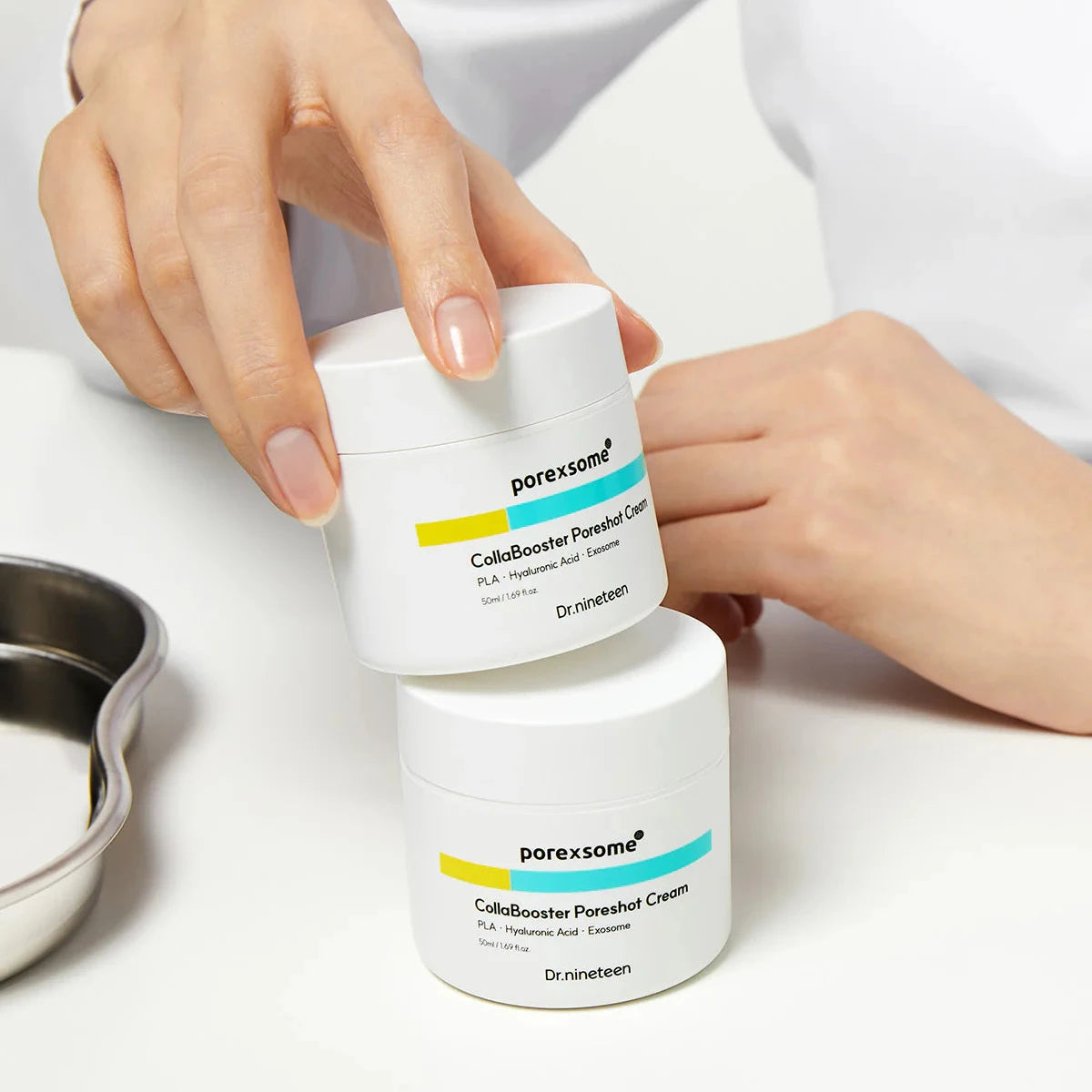 Two containers of porensome ColloidBooster Poreshot Cream on a white surface with a hand holding one.
