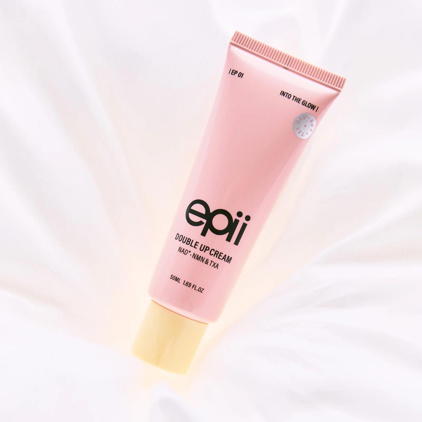 Pink tube of epii Double Up Cream on a white background