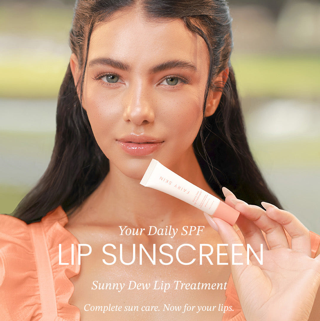 Woman holding a lip sunscreen product with 'Fairy Skin' branding.