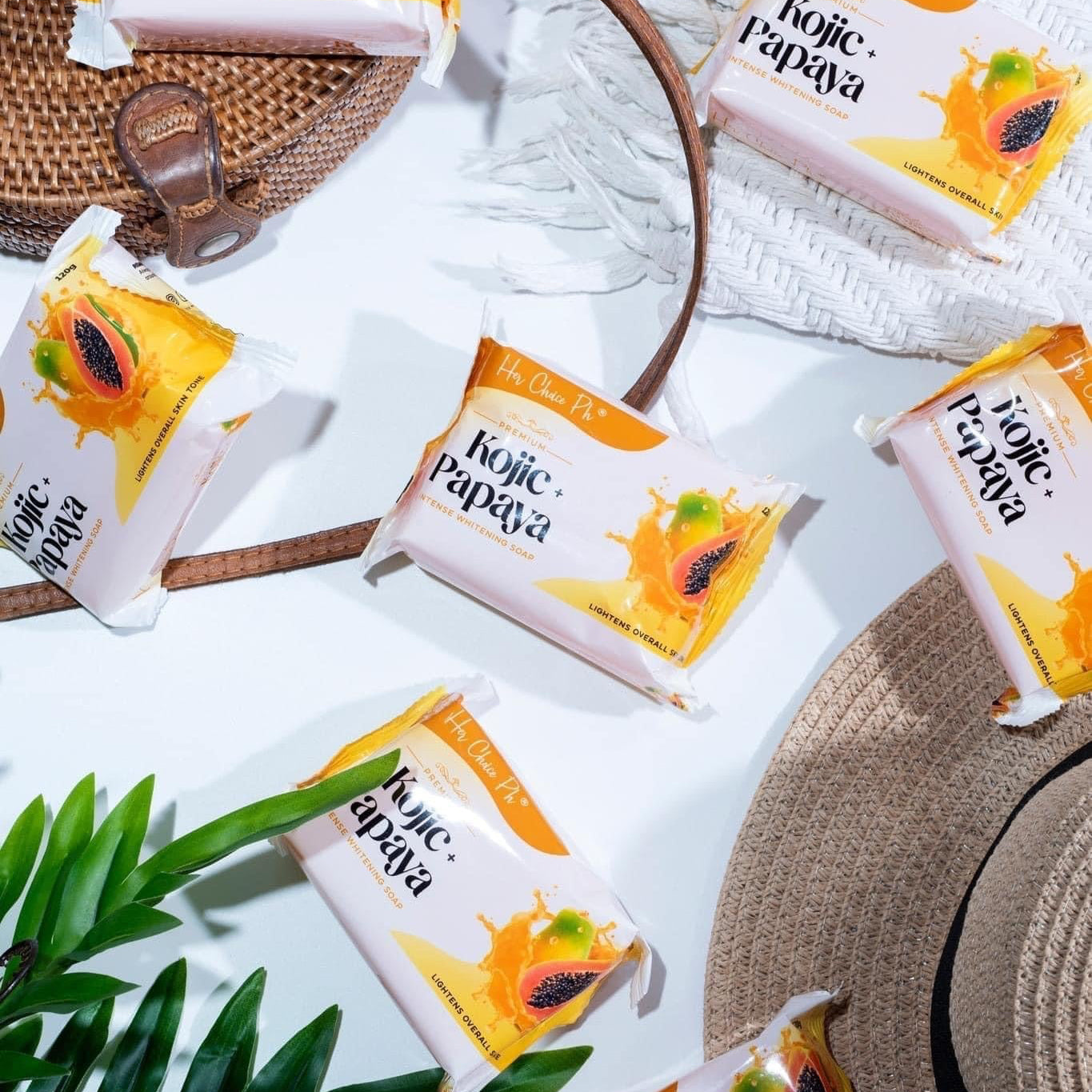 Kojic Papaya skincare products with a woven basket and leaves on a light background