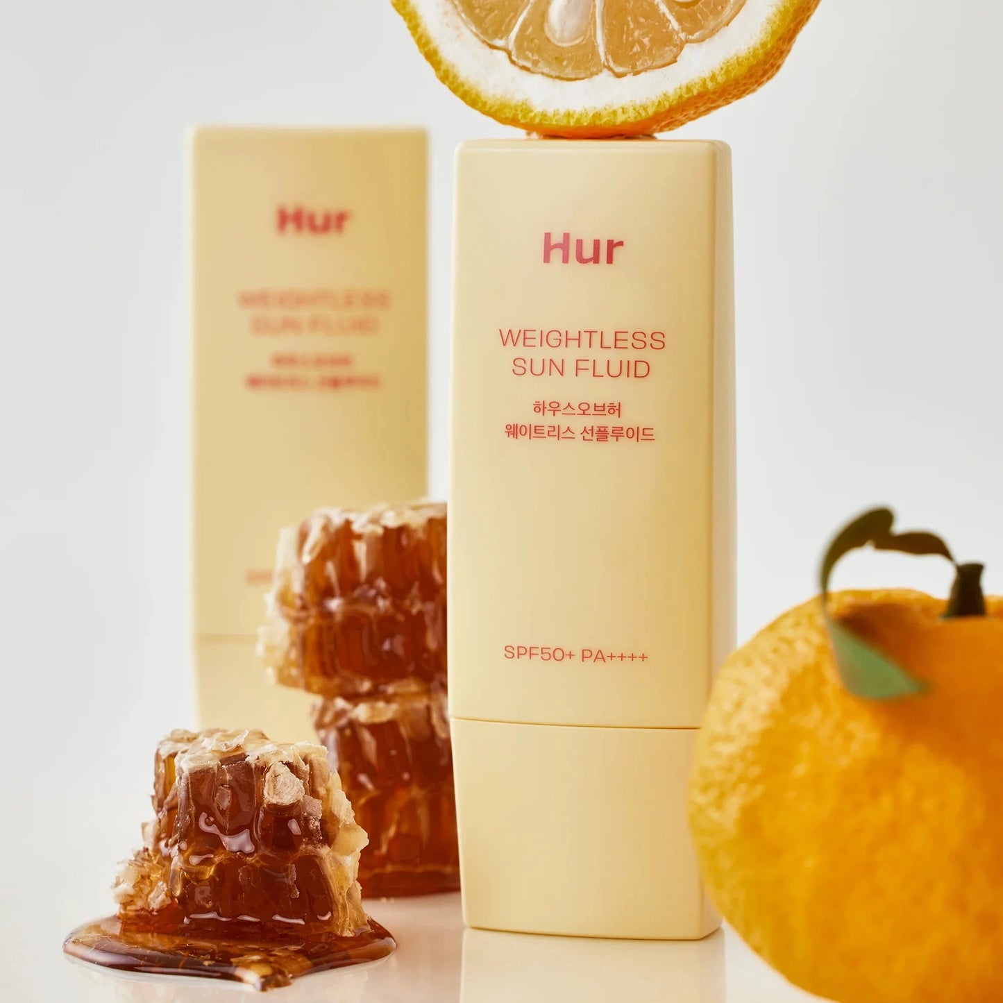 Sun fluid product with honeycomb and orange on a light background