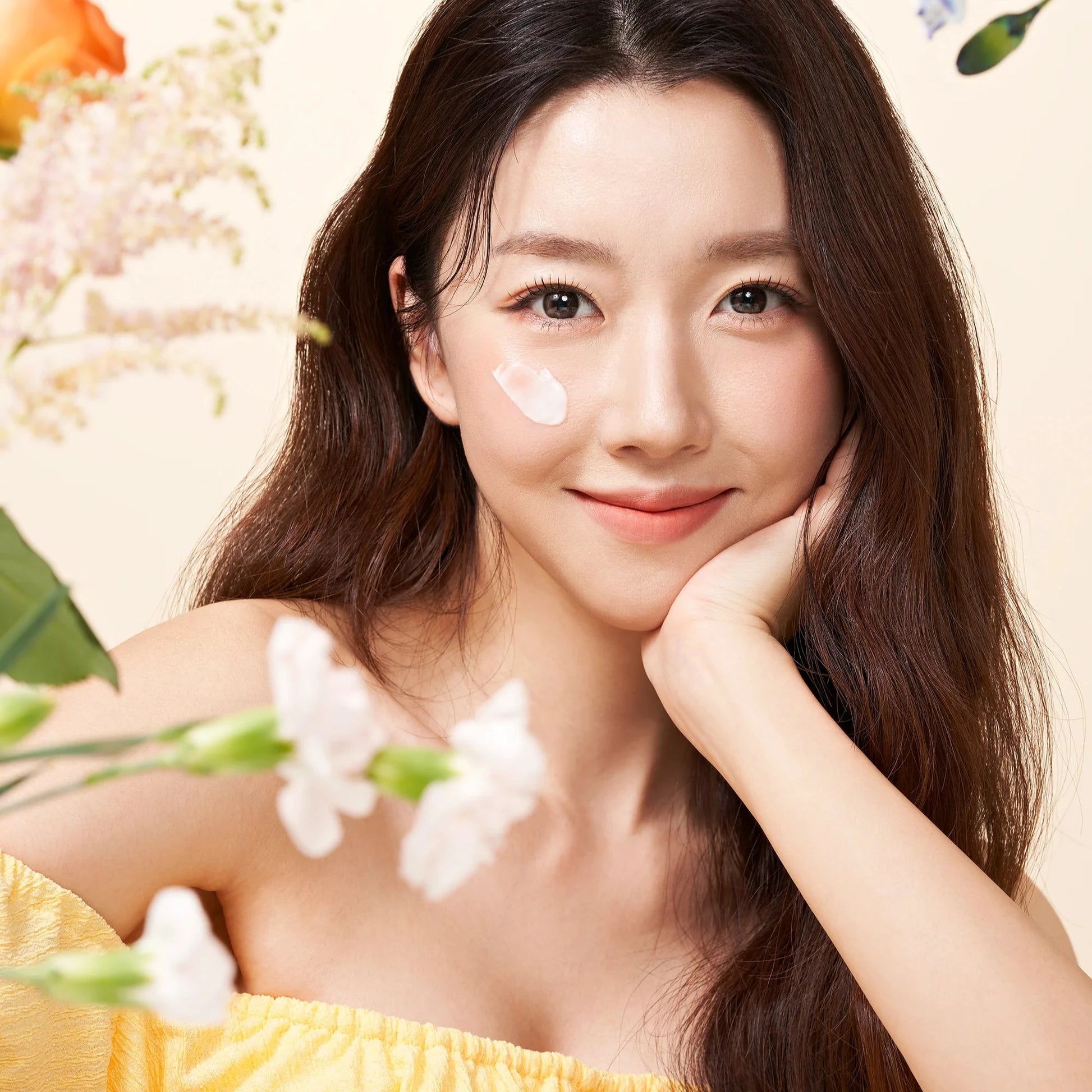 Woman with a floral background, wearing a yellow dress.