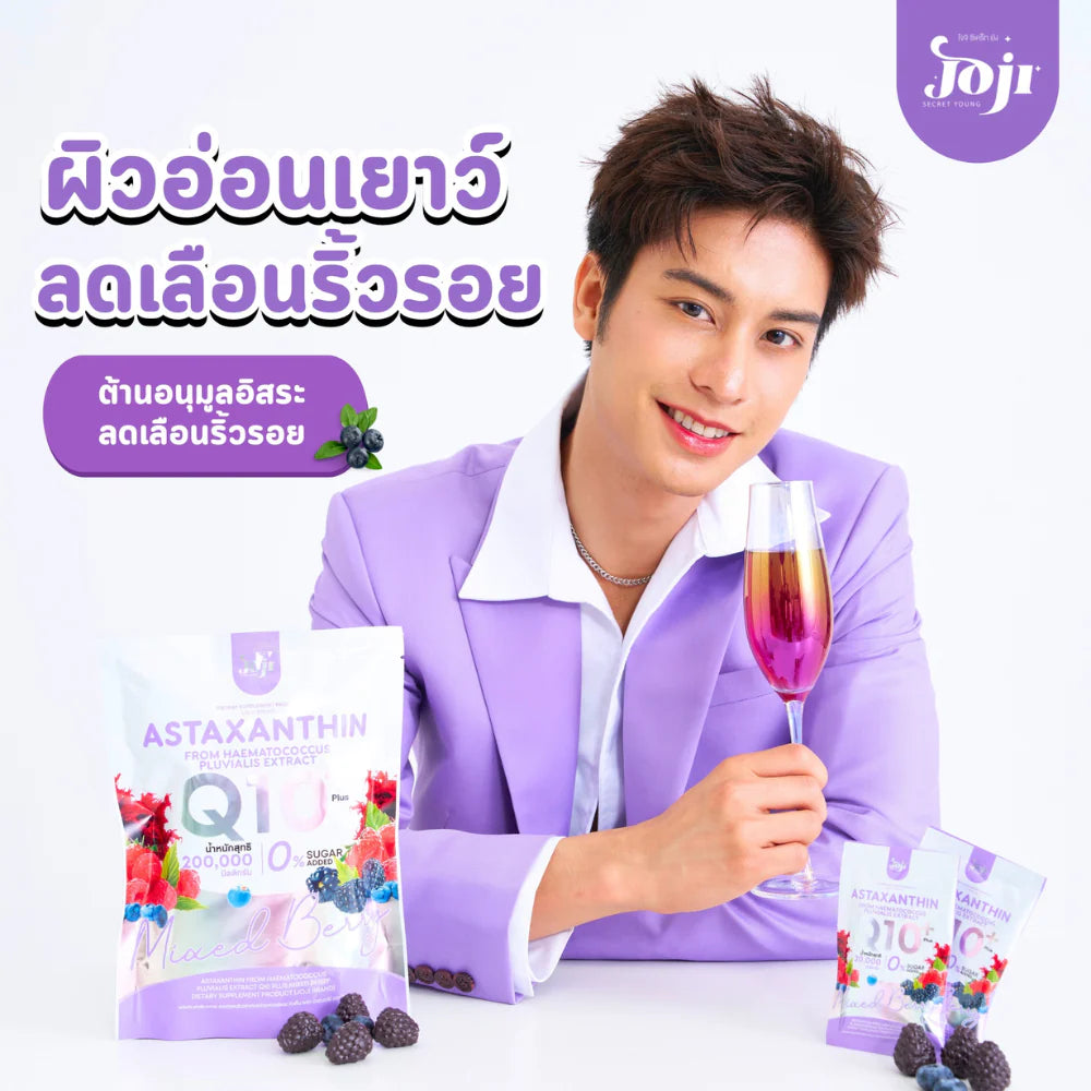 Man in a purple suit holding a glass of pink drink with Astaxanthin and Q10 supplements on a white background