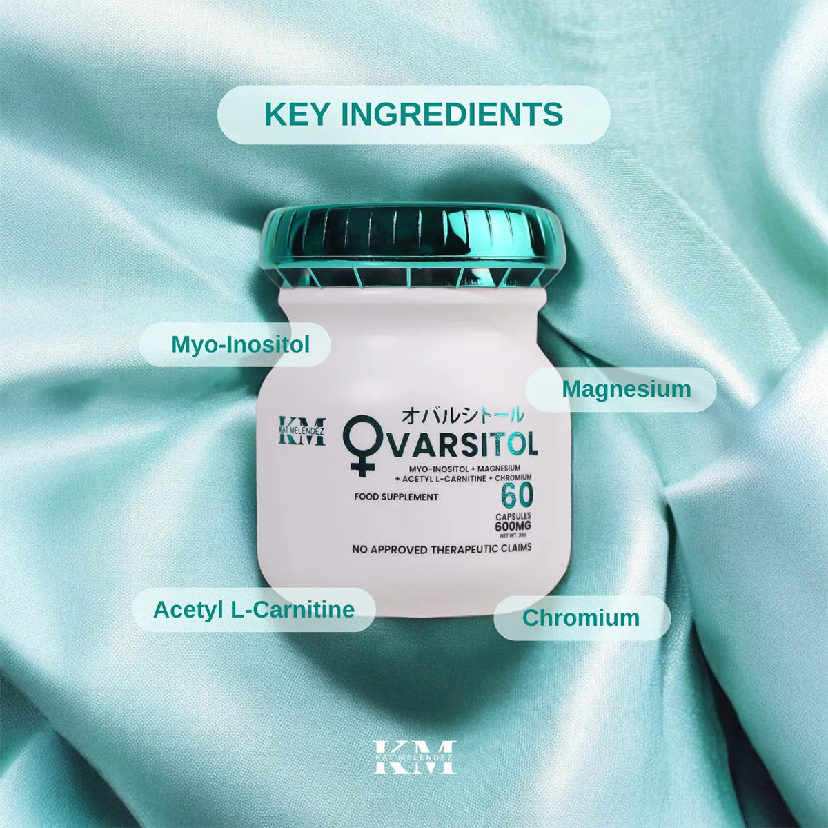KM Q-Varsitol supplement bottle with key ingredients labeled on a light blue fabric background