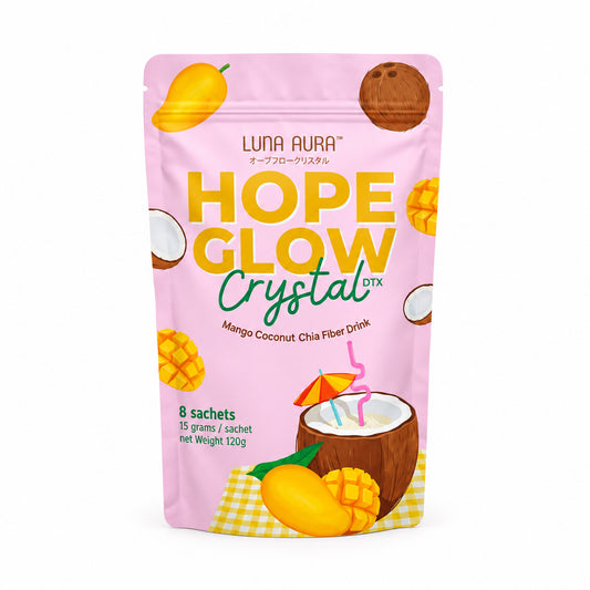 A stand-up pouch of Luna Aura Hope Glow Crystal drink mix, mango coconut flavor, shown on a white background with a pink 'New Product!' badge and the TeamskinCare logo above. The pouch is light pink with yellow and green text and fruit illustrations.