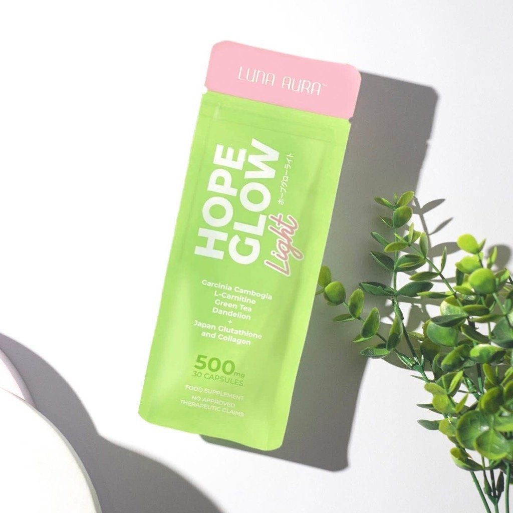 Green supplement packet labeled 'Hope Glow' on a white surface with a plant in the corner.
