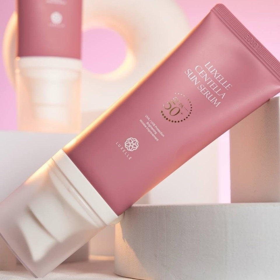 Sun serum packaging with a pink and white design on a soft pink background