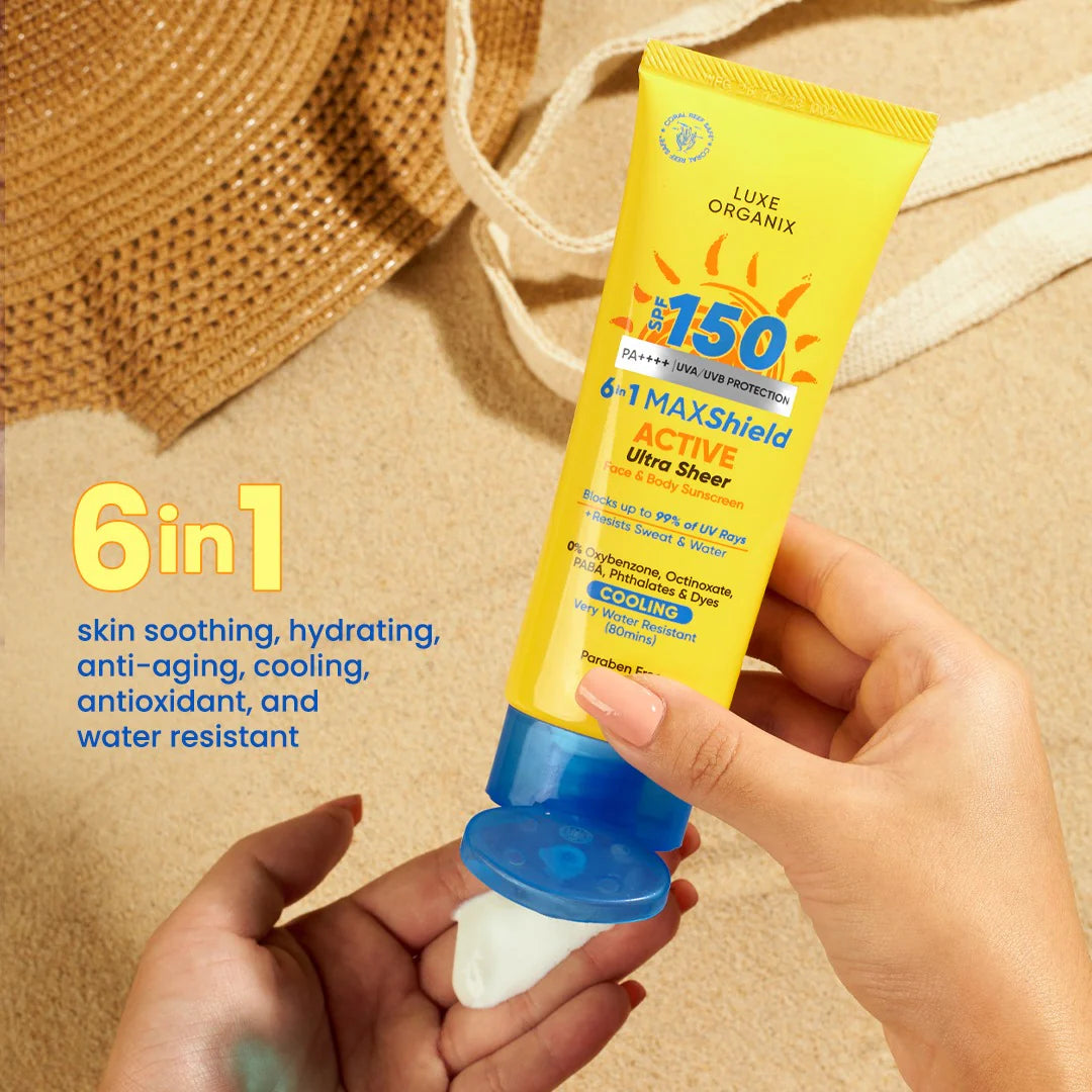 Hand holding a Luxe Organix sunscreen tube with SPF 150 on a beige background