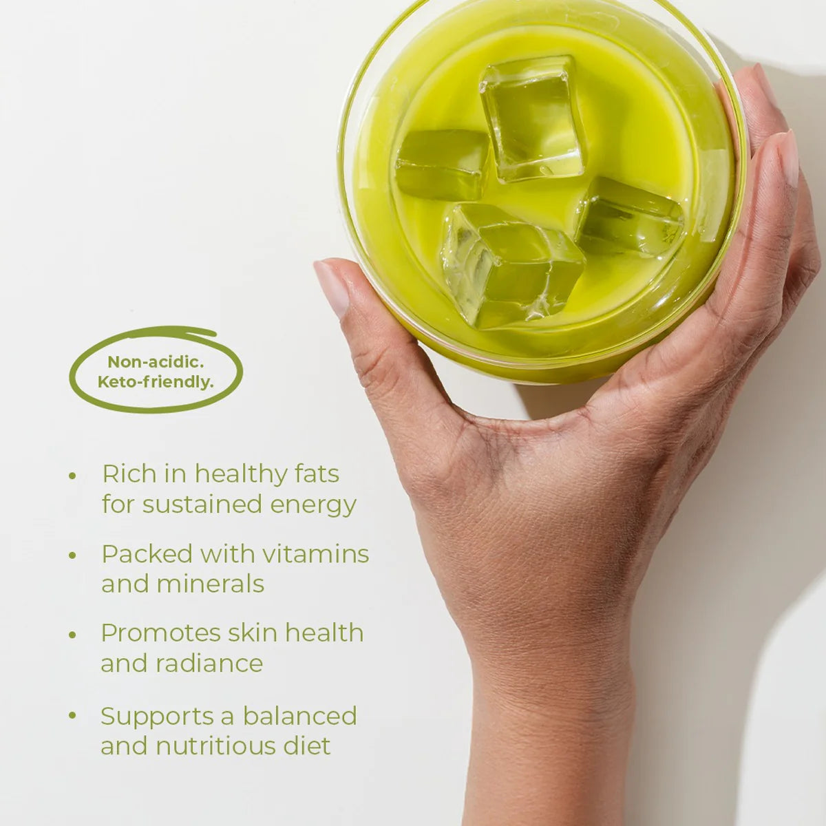 Hand holding a green smoothie with ice cubes on a white background, featuring text about health benefits.