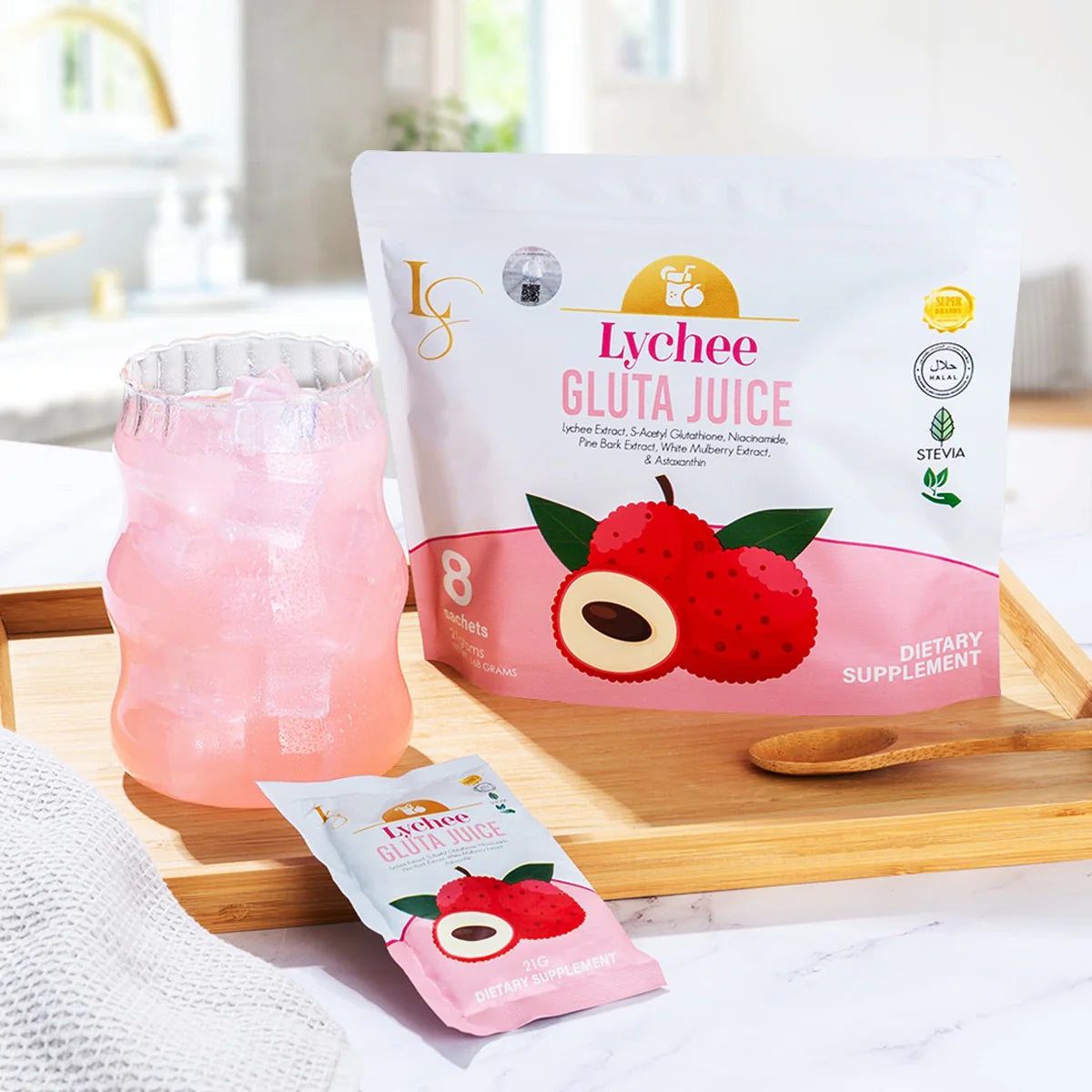 Lychee Gluta Juice package with a glass of pink juice on a wooden tray.