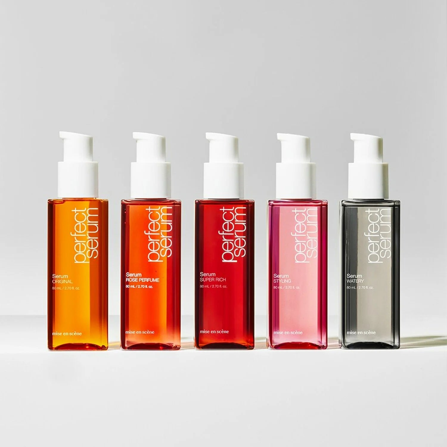 Five bottles of 'perfect serum' in different colors on a light gray background