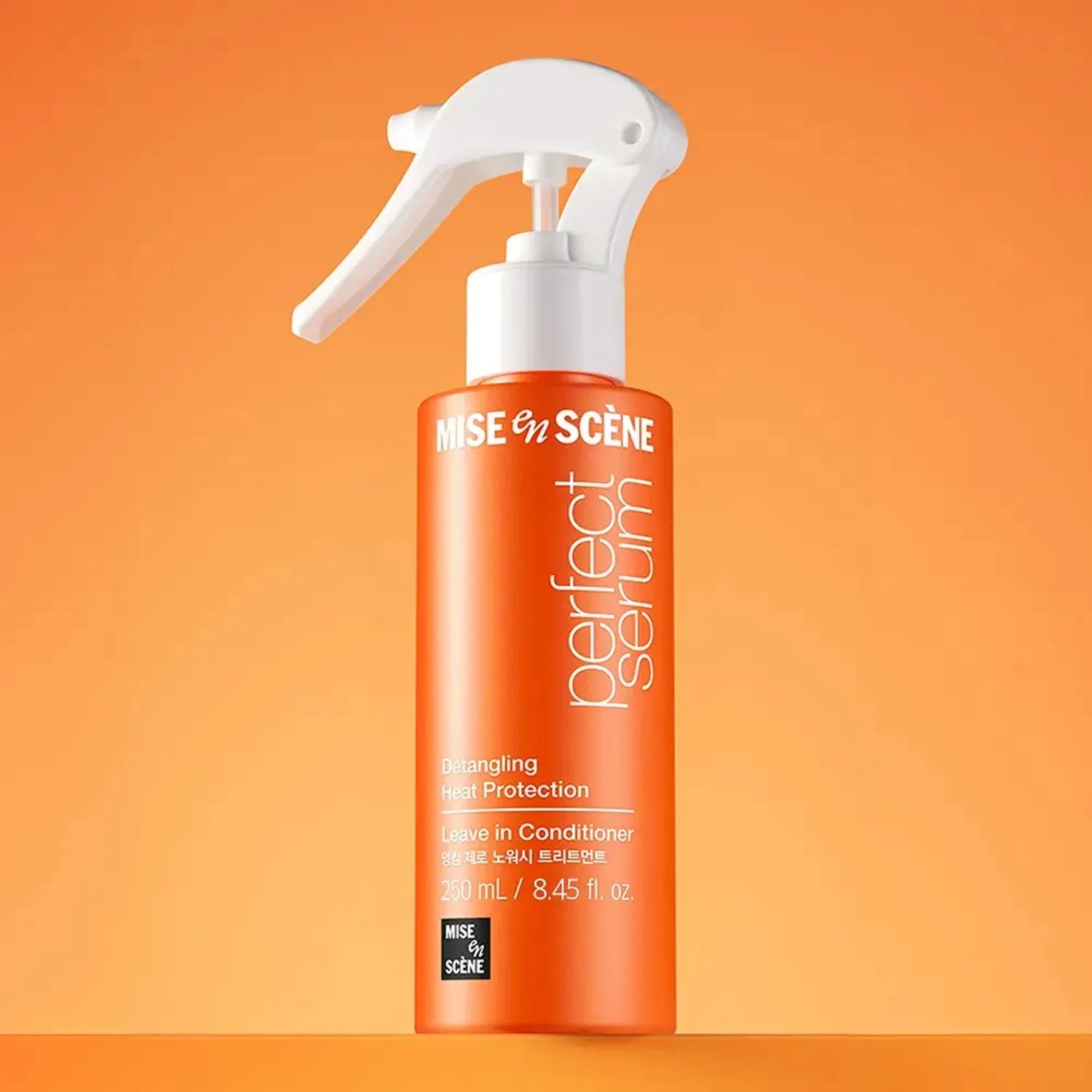 Orange spray bottle with white nozzle on an orange background