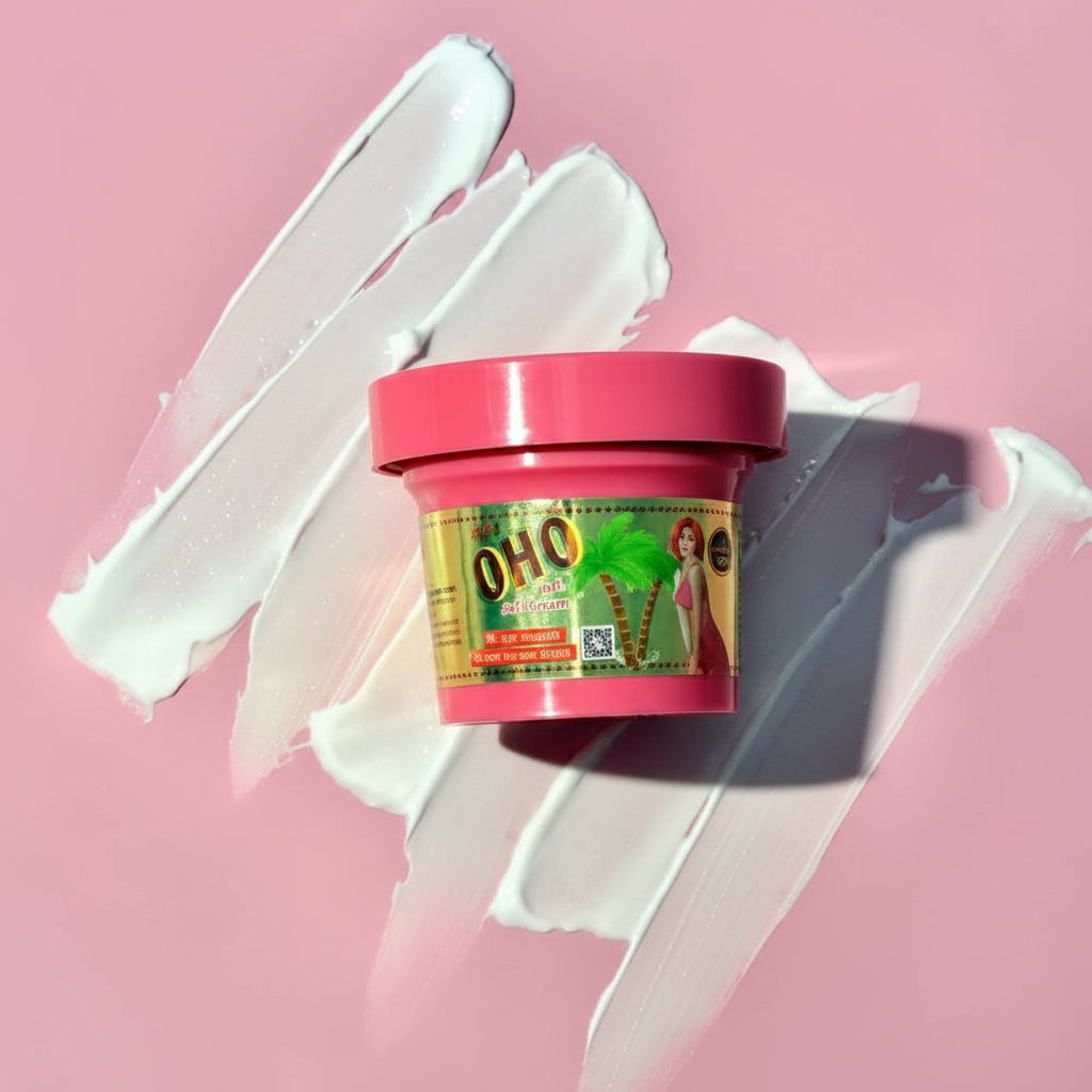 A small jar of OHO hair product with a pink lid and green/yellow label, placed on a pink background with white cream smears behind it.
