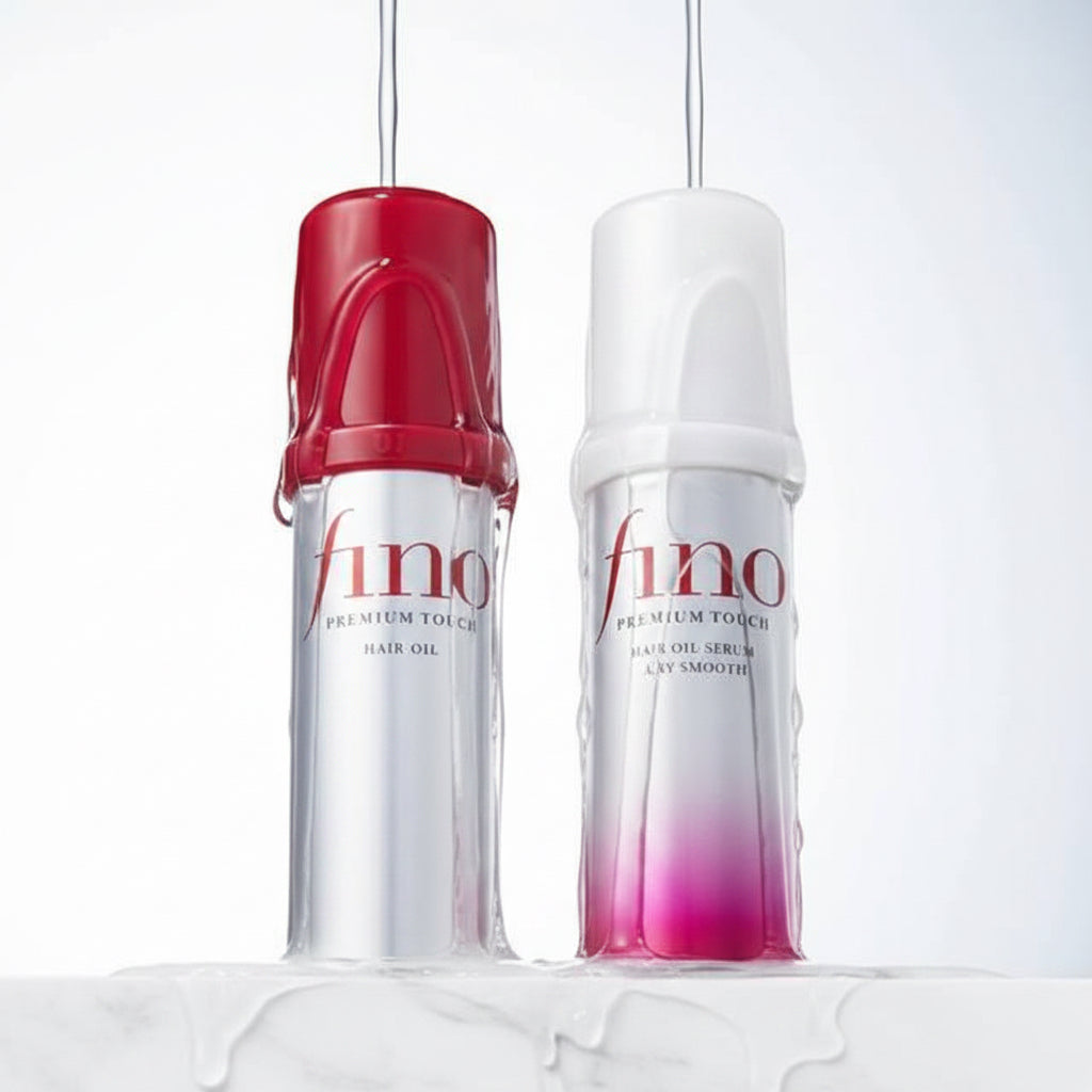 Two Fino hair care bottles on a white surface with water droplets and flowing water in the background. The left bottle is silver with a red cap and red lettering, and the right bottle is white with a pink-to-red gradient base and red lettering.